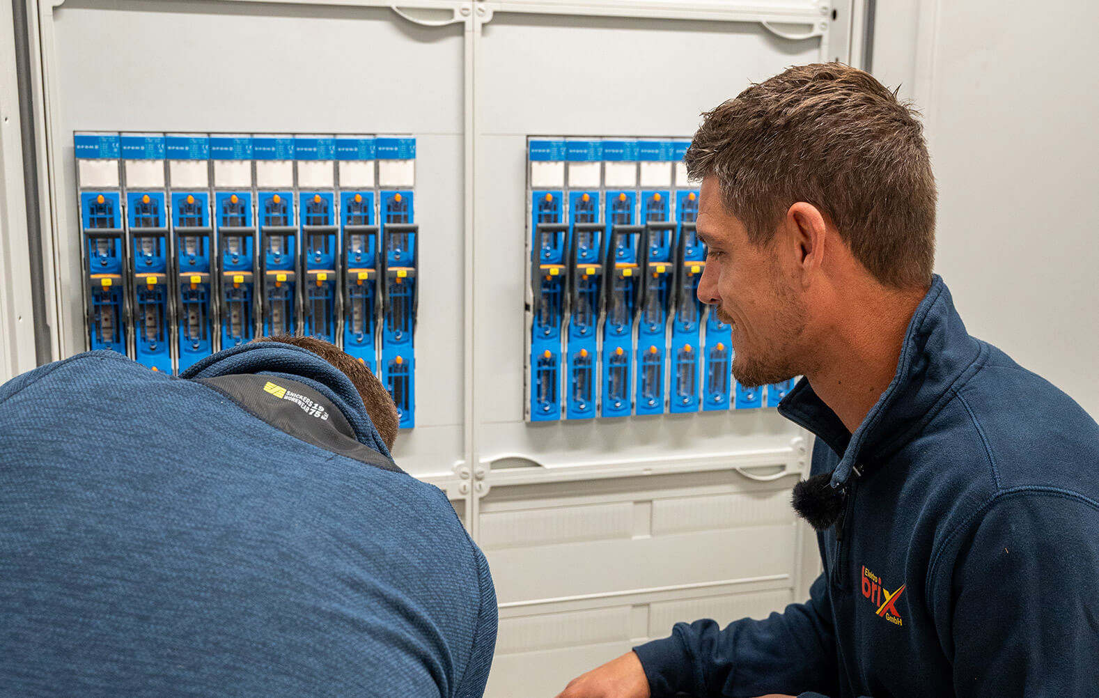 Zwei Angestellte von Elektro Brix an einem Schaltschrank