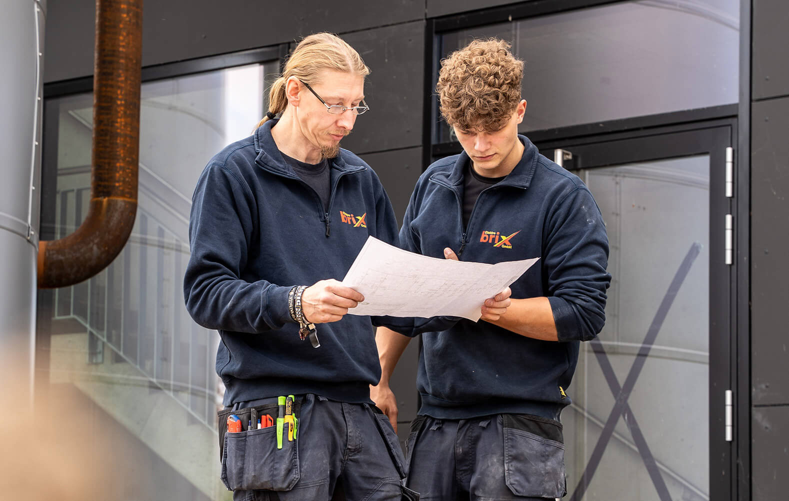 Zwei Angestellte von Elektro Brix lesen einen Plan