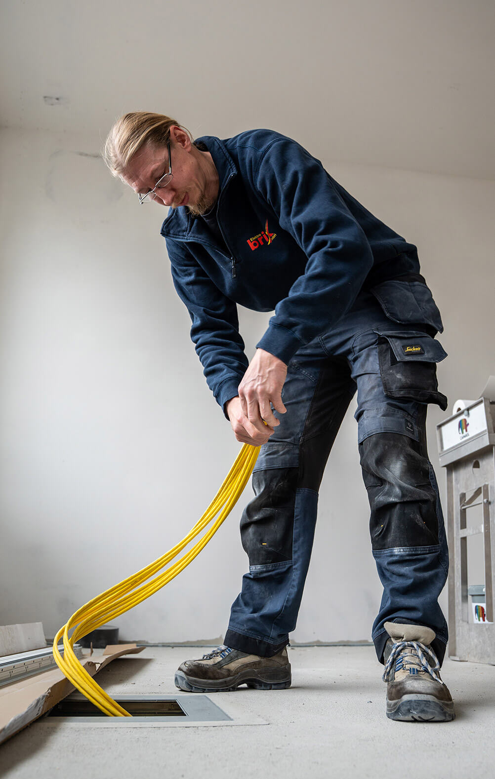 Ein Angestellter von Elektro Brix legt eine Leitung